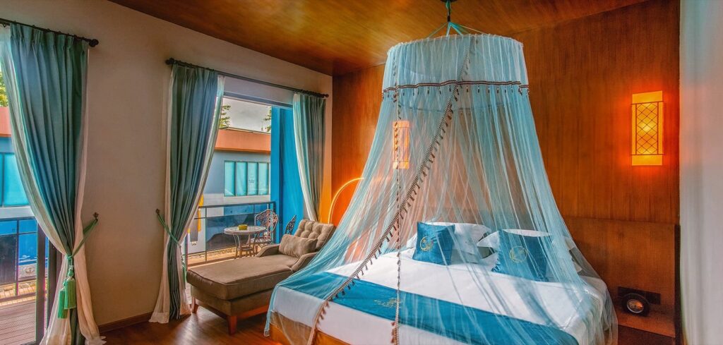 Deluxe King Room with a canopy bed, daybed and balcony doors
