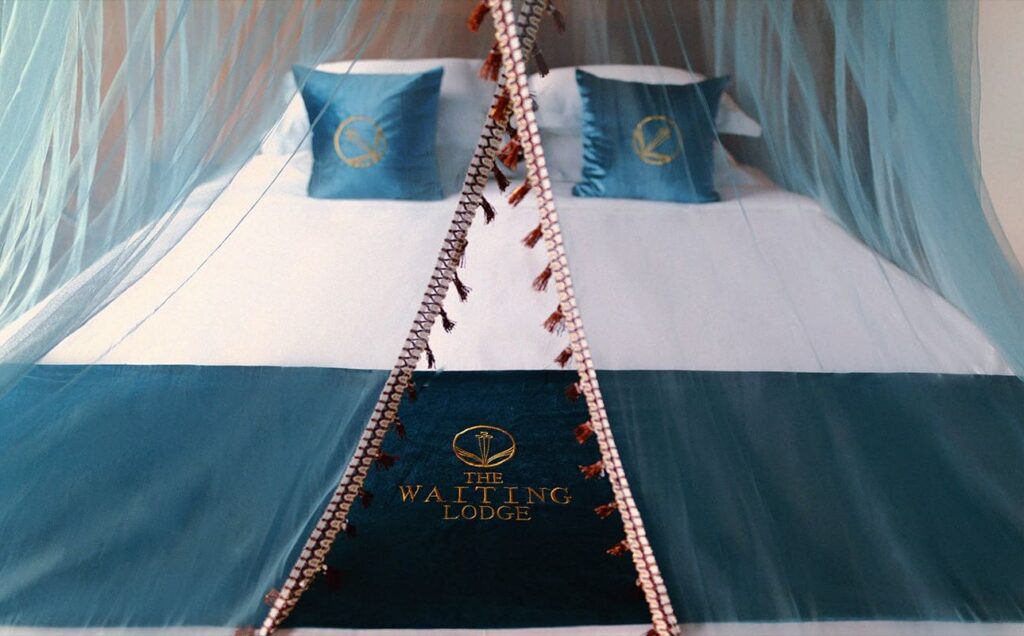 King-size bed with embroidered linen under a sheer canopy