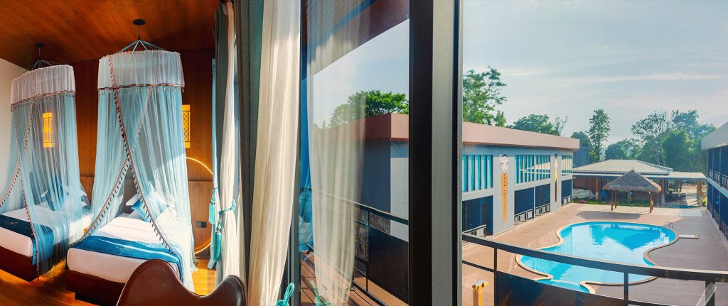 Deluxe Twin Room opening onto a balcony with a view of the pool